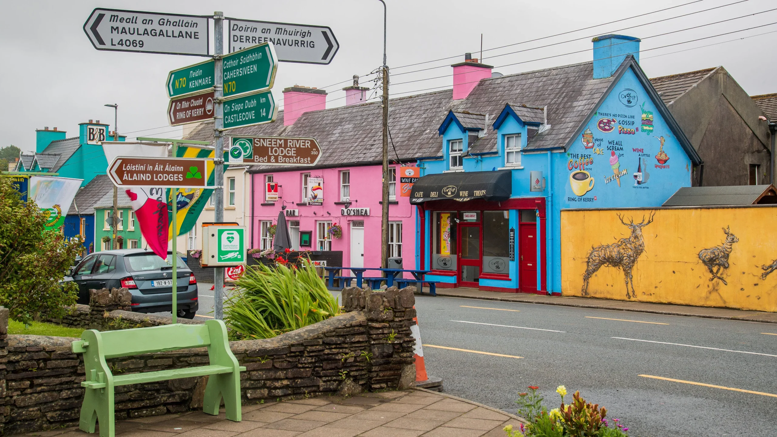 Colorful Irish village street in Sneem with traditional whitewashed cottages and hanging flower baskets